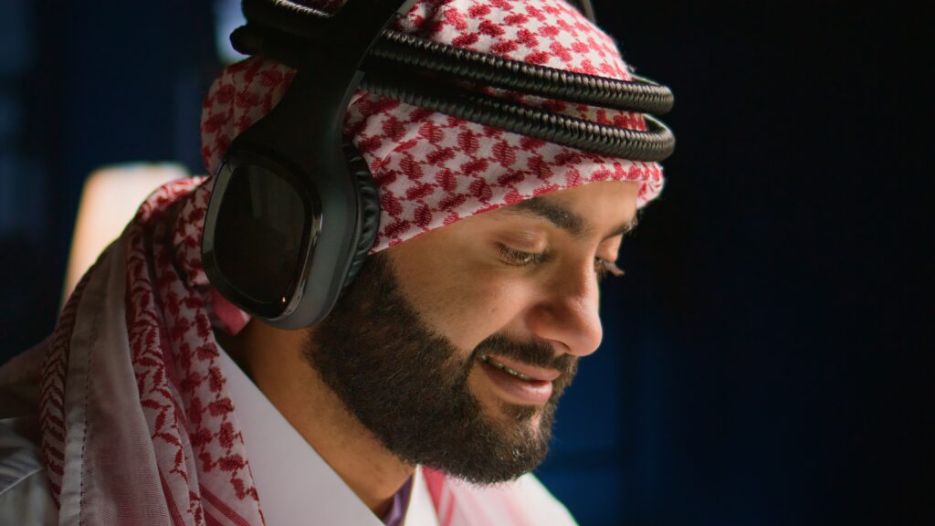 man listening to Quran recitation with headphones for memorization